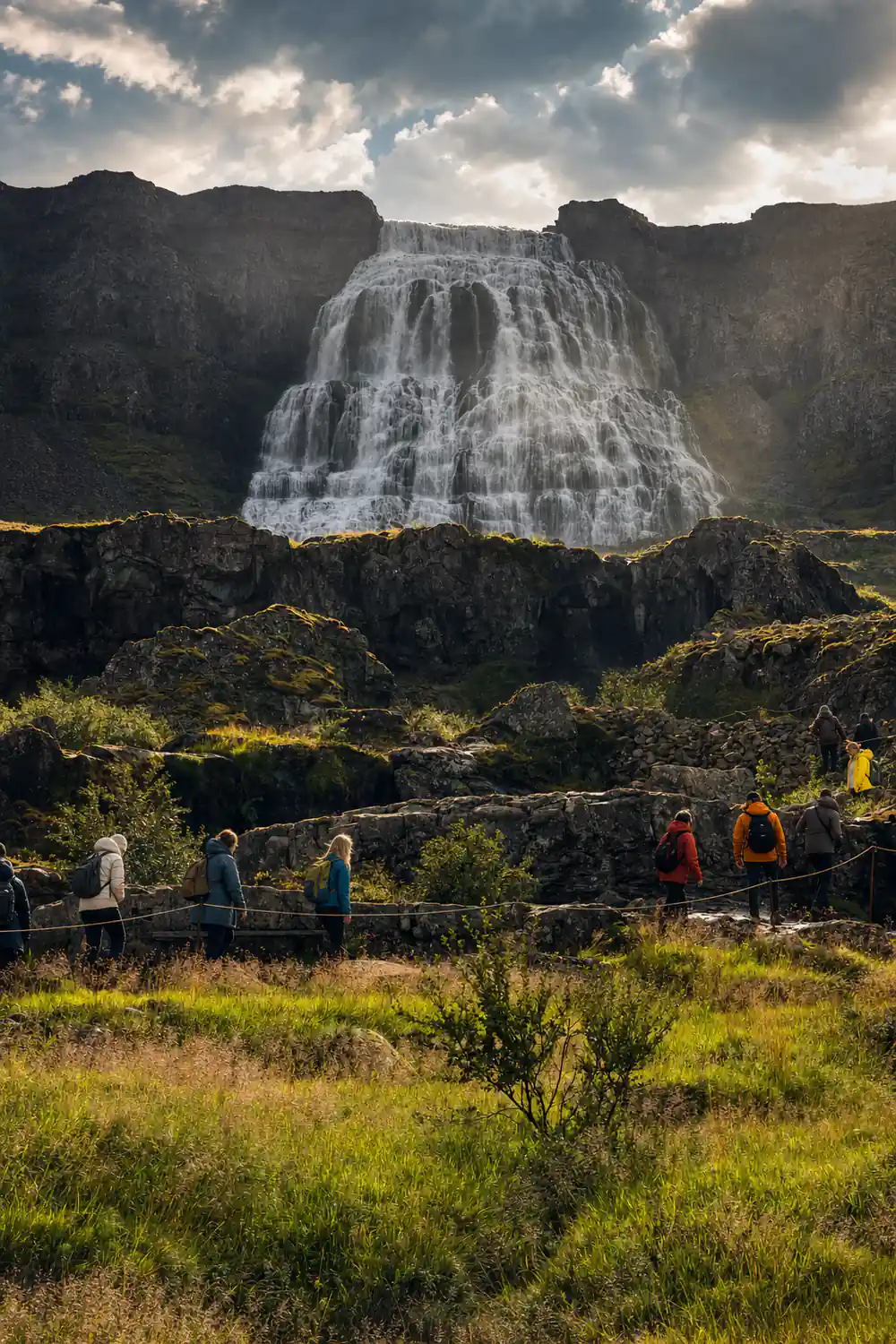 A line of visitors climbing towards Dynjandi in the rain