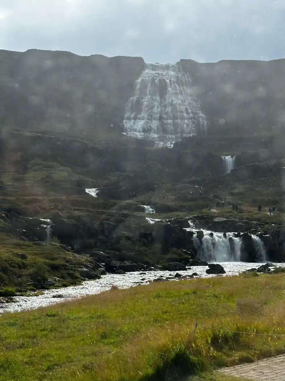 The river running down from the falls across open ground