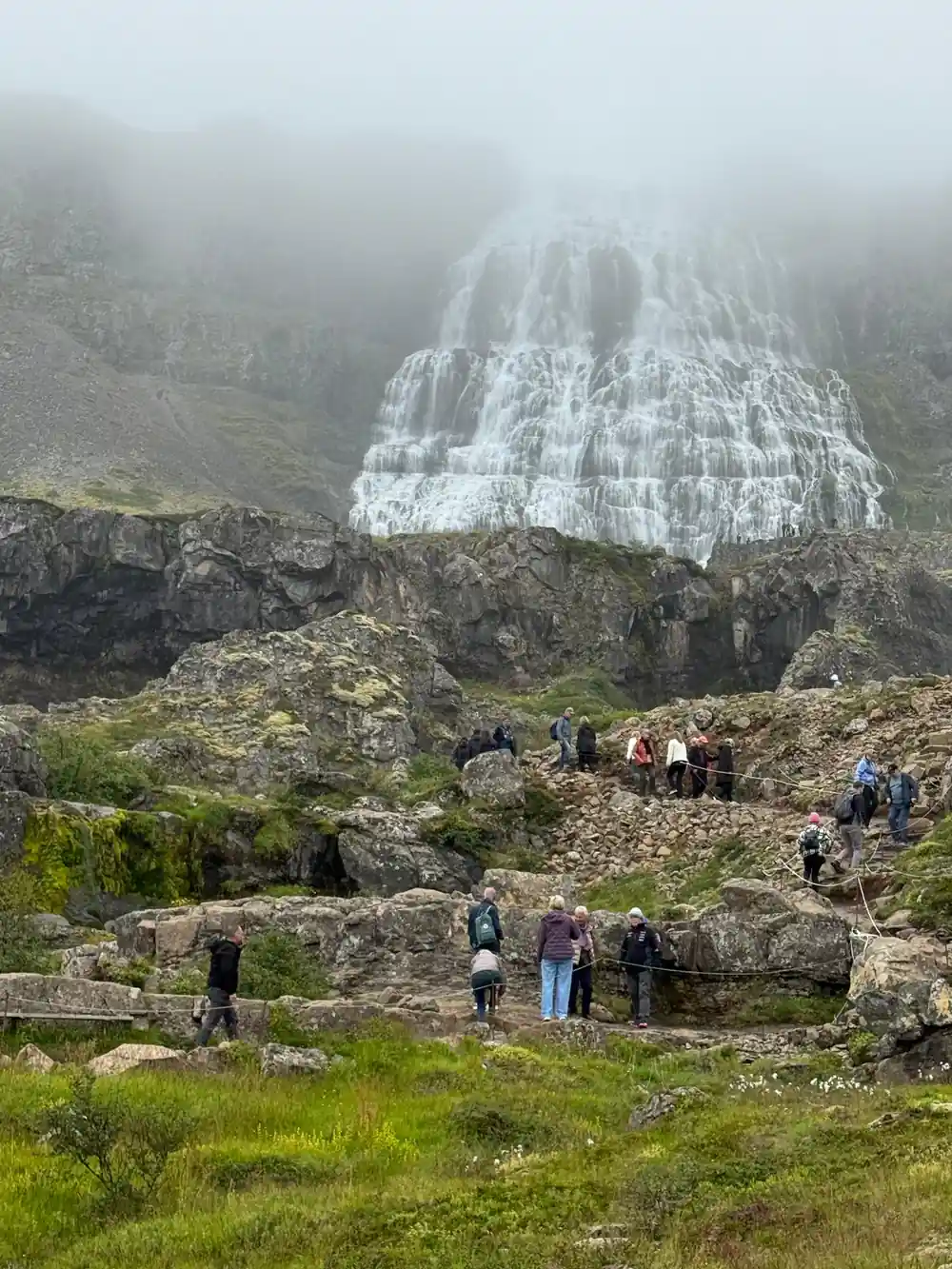 Visitors climbing the path with Dynjandi above them