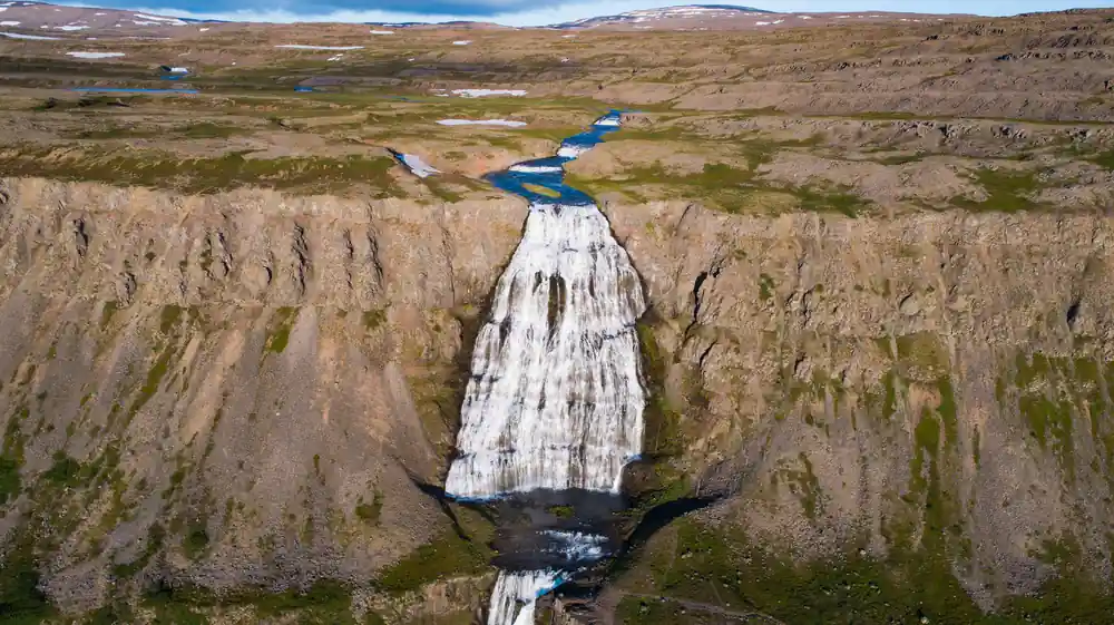 The waterfall from above with the river running to the sea